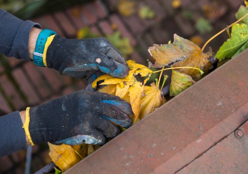 Man with gloves performing Gutter Cleaning in Morton IL